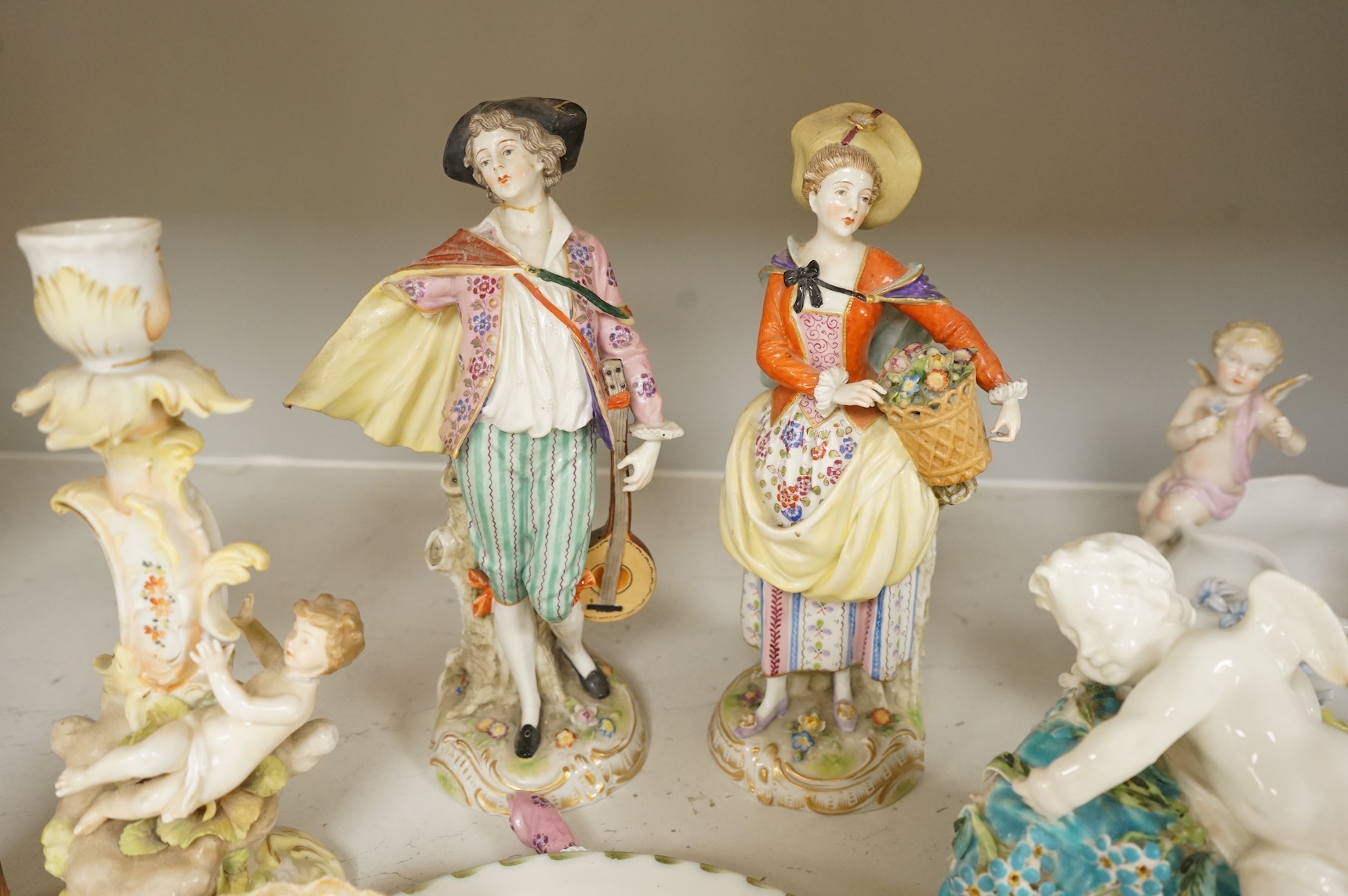 A pair of Sitzendorf figurines, damage to one, a pair of candlesticks, a Rye pottery dish, a Moore Bros. wall pocket, a doll and a basket, tallest 22.5cm
